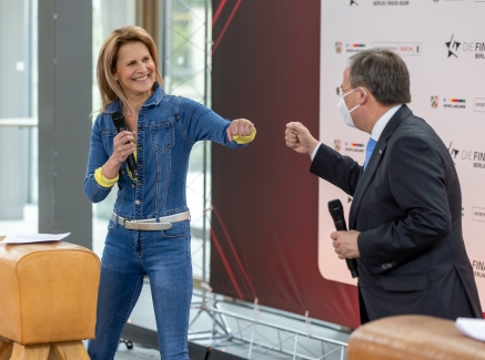 Armin Laschet begrüßt Moderatorin Katrin Müller-Hohenstein mit einem Faustschlag