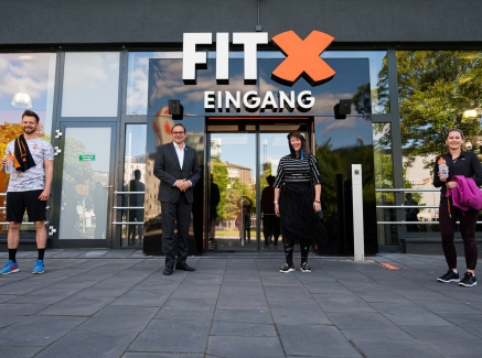 Staatssekretärin Milz vor einem Fitness-Studio-Eingang.