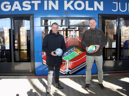 Hansi Flick und Alfred Gislason vor Straßenbahn