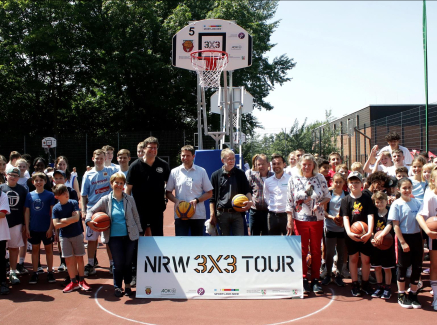 Menschen unter Basketballkorb im Freien