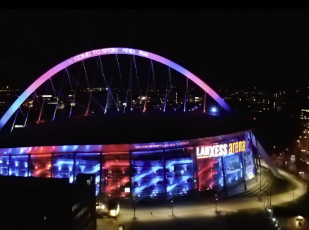 Blick von oben auf die illuninierte Lanxess arena in Köln mit Schriftzug Welcome to Sportland.NRW