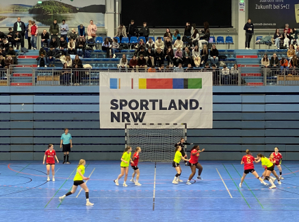 Ein Handball-Spiel vor dem Sportland.NRW-Logo