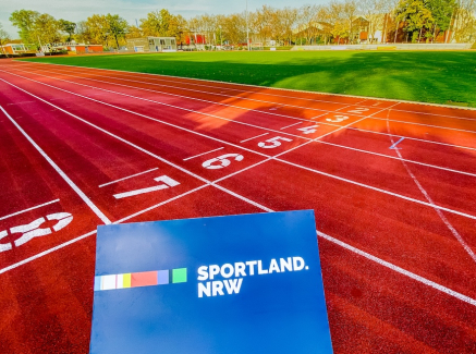 Laufbahn mit blauem Sportland.NRW-Schild