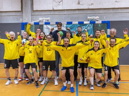 Julian Köster jubelt mit vielen Personen bei einem Handball-Training