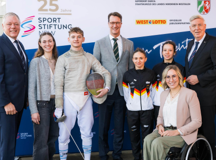 Acht Personen beim Jubiläum der Sportstiftung vor einem Banner
