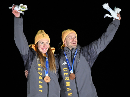 Jacqueline Pfeifer und Christopher Grotheer mit Medaillen um den Hals vor dunklem Hintergrund