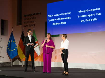 Bühne mit Redner, Andrea Milz und Eva Selic 