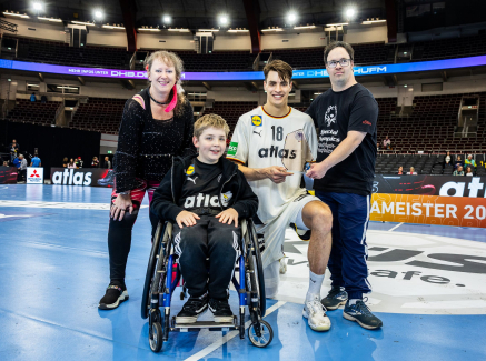 Andrea Milz und Julian Köster mit zwei weiteren Jugendlichen, einer davon im Rollstuhl, auf einem Handballfeld