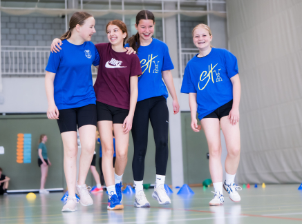 Vier junge Frauen in Sportkleidung in einer Halle