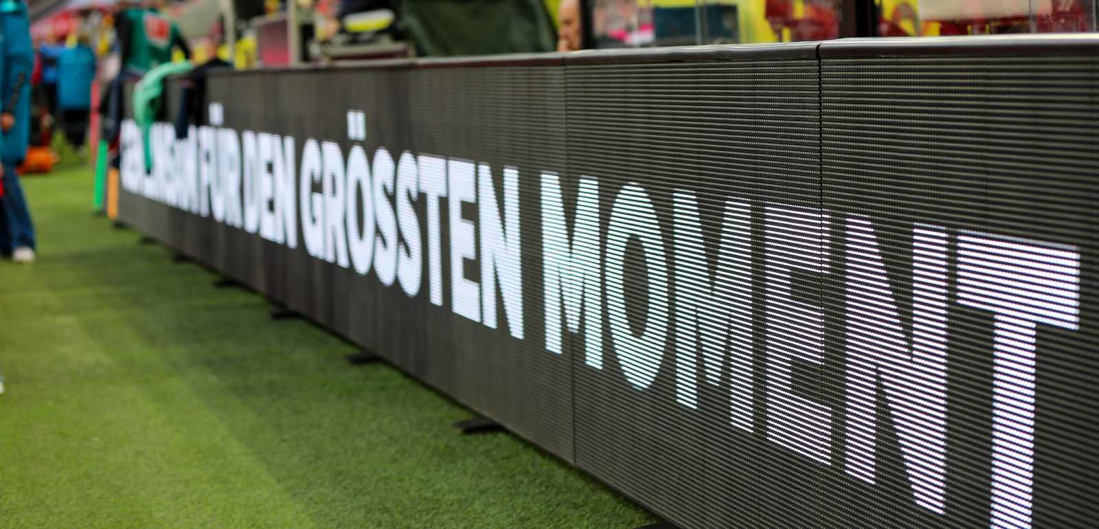 Dunkle Bande im Fußballstadion mit der Aufschrift "Für den größten Moment"