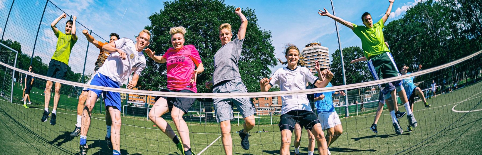 Jugendliche beim Sport. Sie springen fröhlichen in die Luft