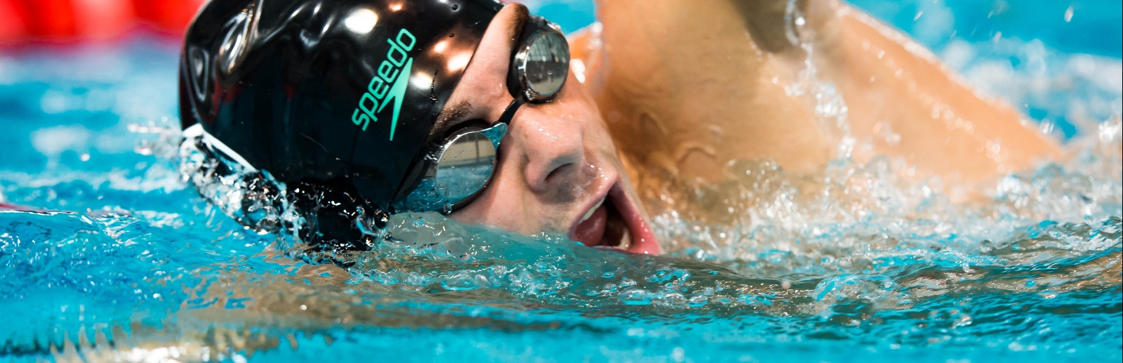 Ein Schwimmer in schwarzer Badekappe und Schwimmbrille 