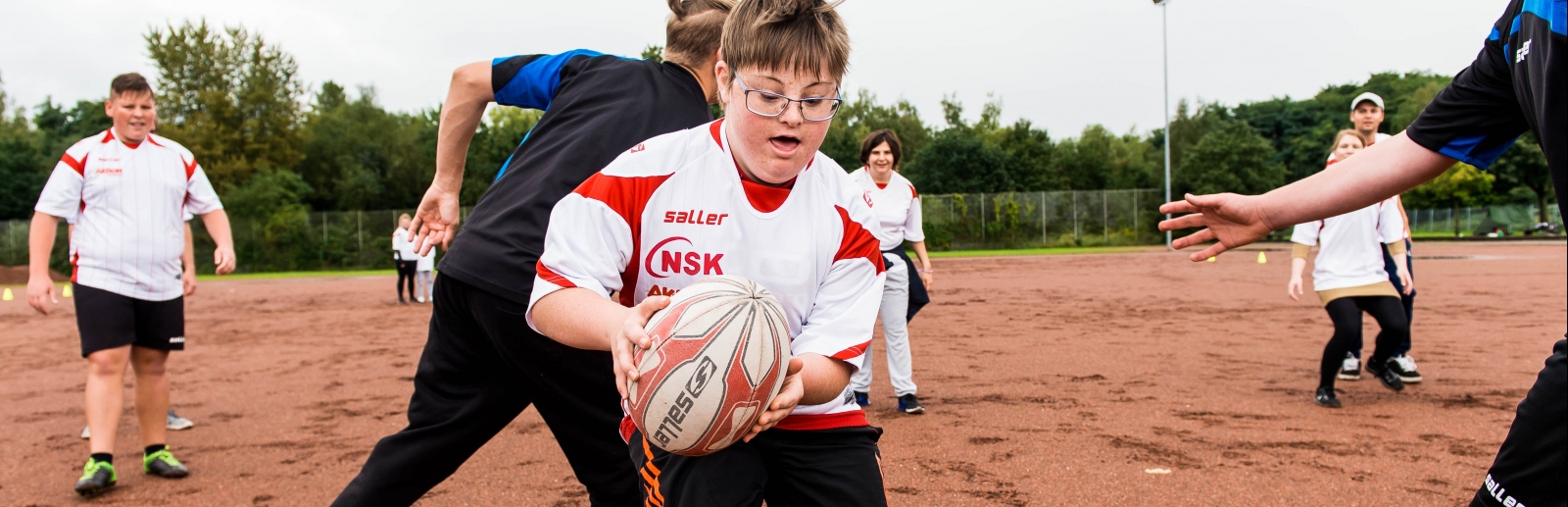 Mehrere Jungen beim Soft-Rugby-Spiel ohne Schutzasurüstung.