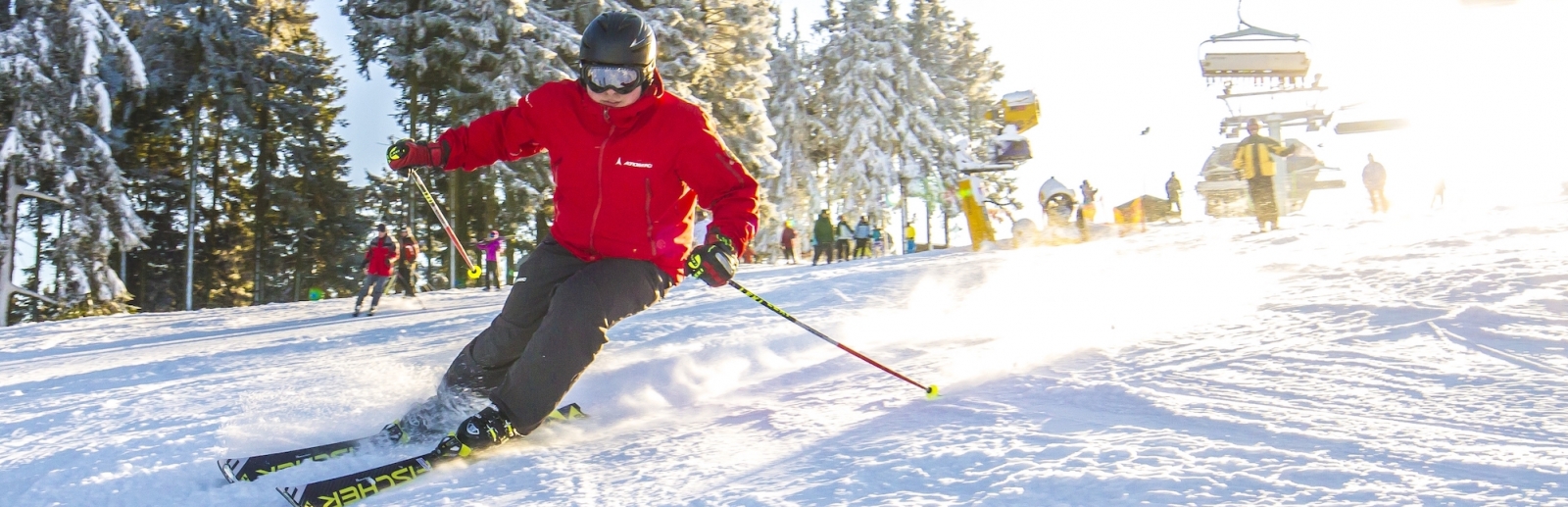 Ein Skifahrer fährt Piste hinunter. 