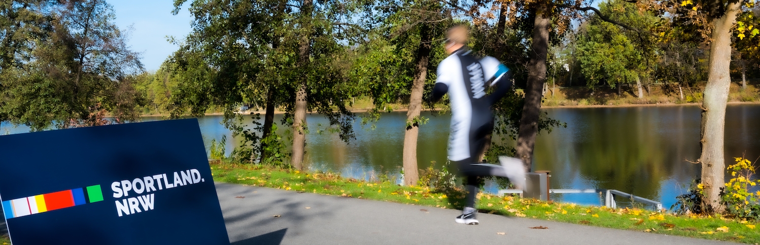 Sportland.NRW-Banner an einer Joggingstrecke