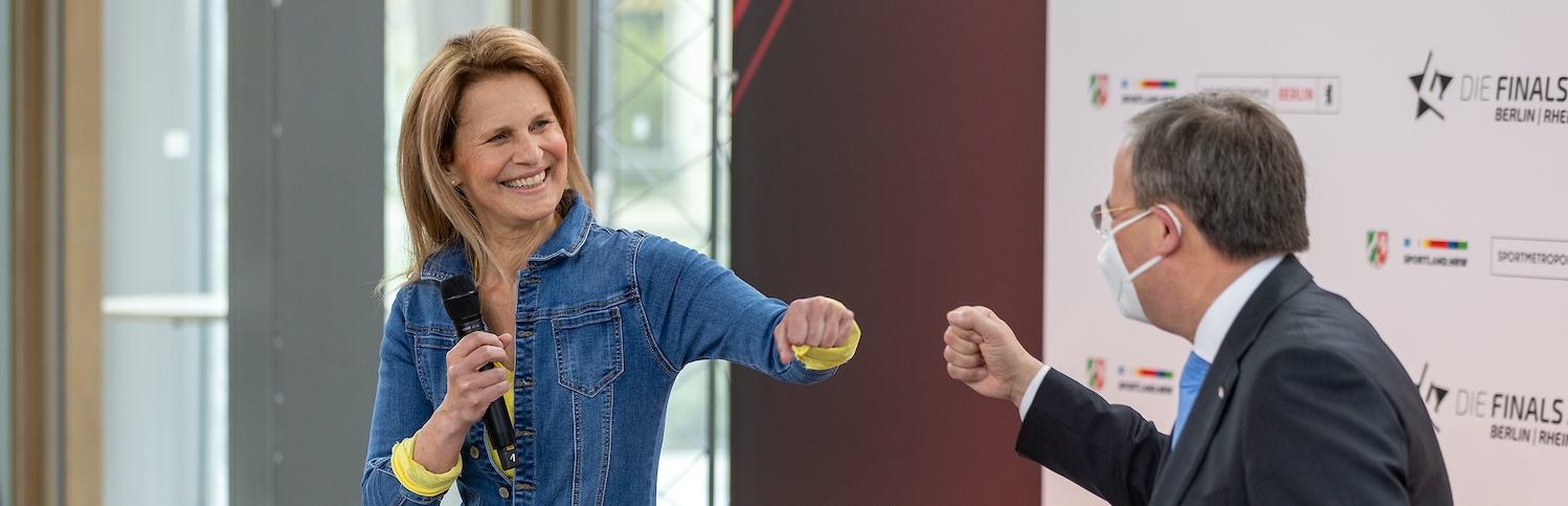 Armin Laschet begrüßt Moderatorin Katrin Müller-Hohenstein mit einem Faustschlag