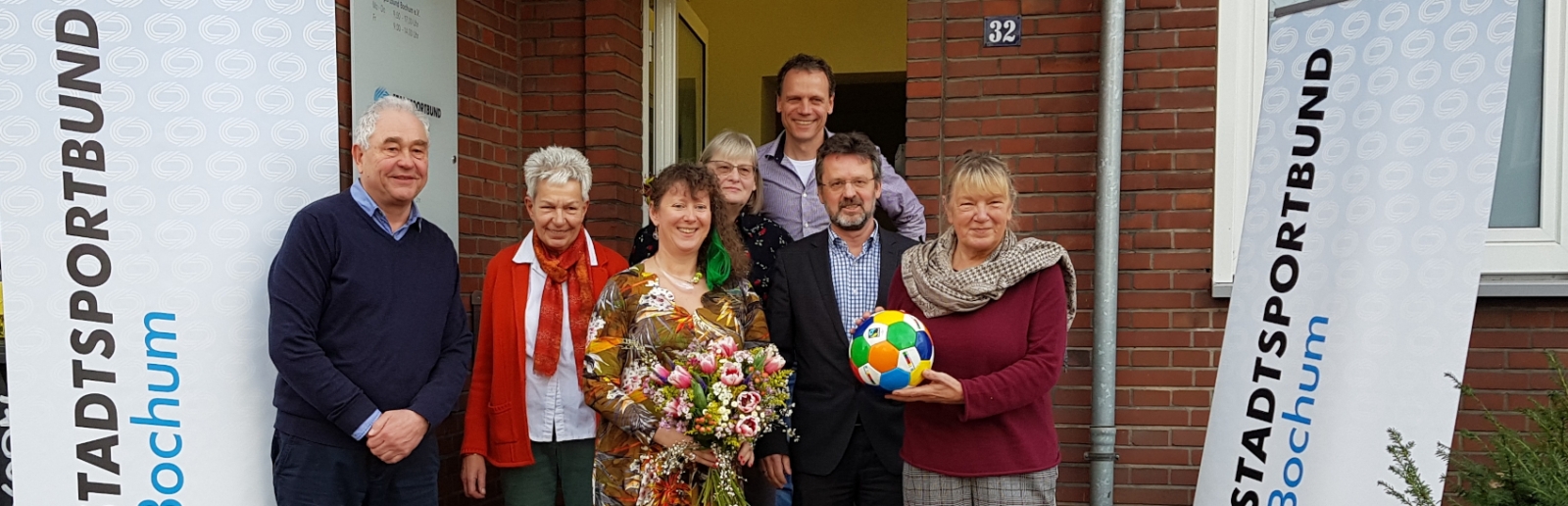 Staatssekretärin Andrea Milz mit den Vorstandsmitgliedern des Sportbunds Bochum vor dem Vereinsgebäude.