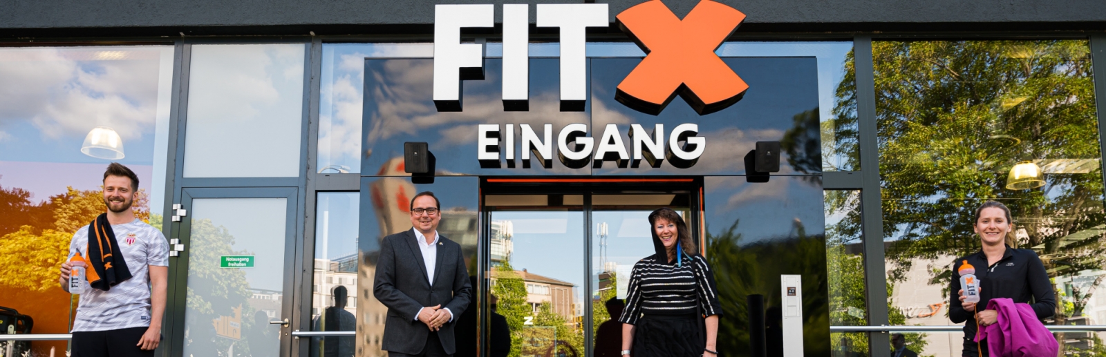 Staatssekretärin Milz vor einem Fitness-Studio-Eingang.