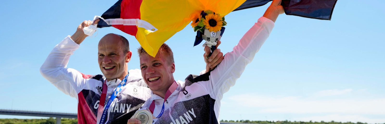 Hoff und Schopf mit Deutschland Fahne und Silbermedaille vor blauem Himmel