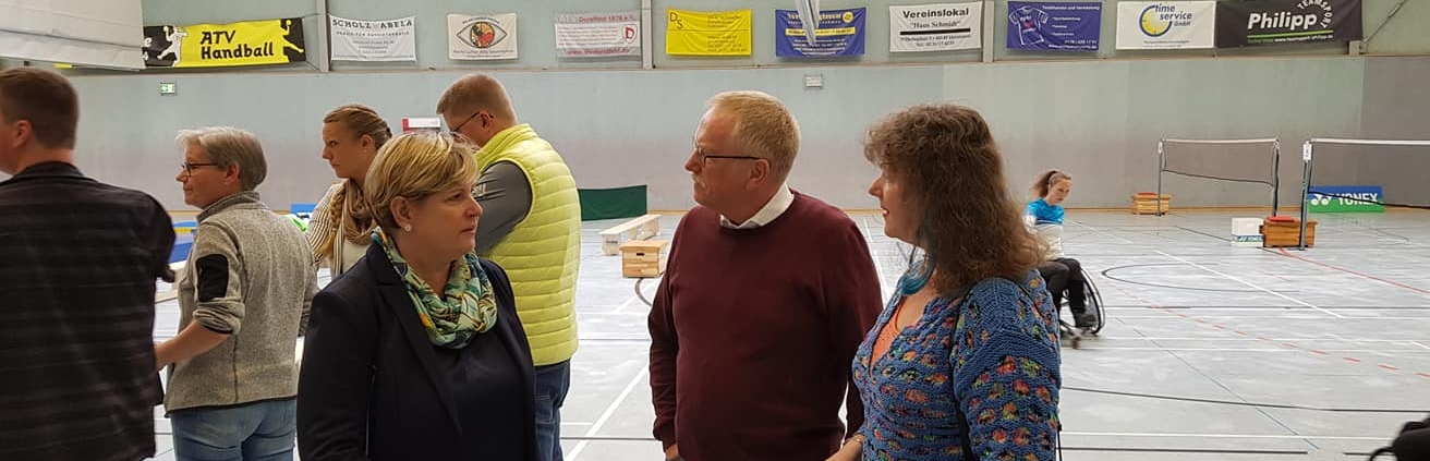 Staatssekretärin Andrea Milz im Gespräch mit Frau Claudia Middendorf und Herrn Reinhard Schneider in der Sporthalle in Dortmund.