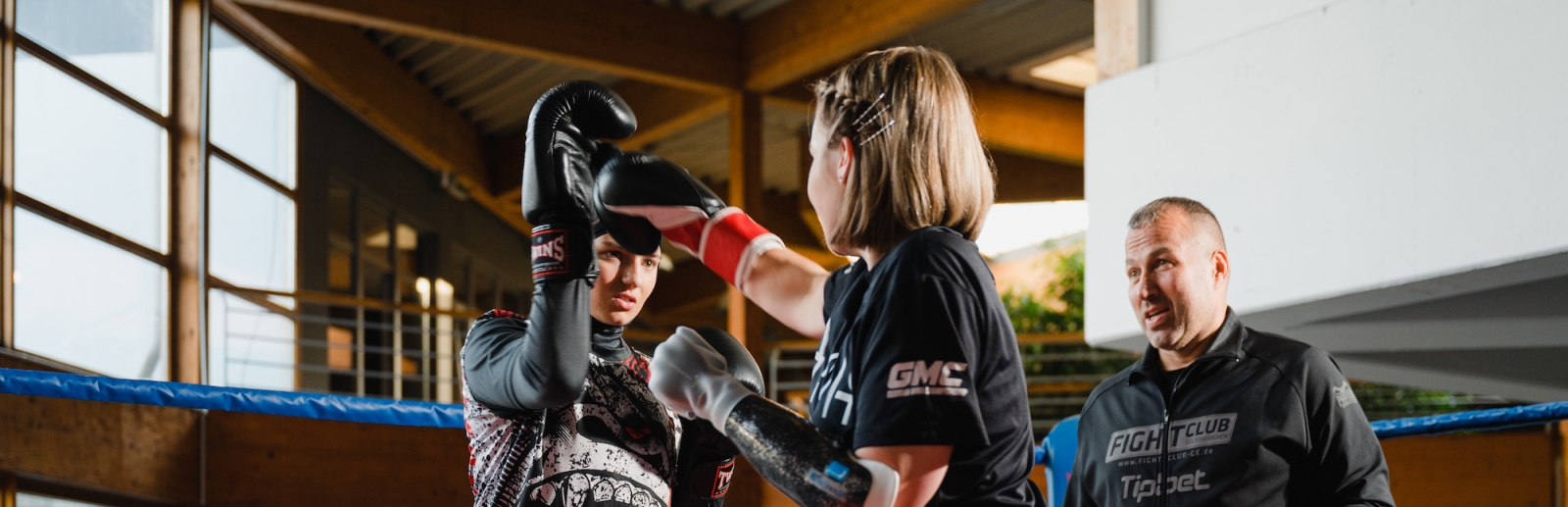 Zwei Boxerinnen mit Coach im Ring