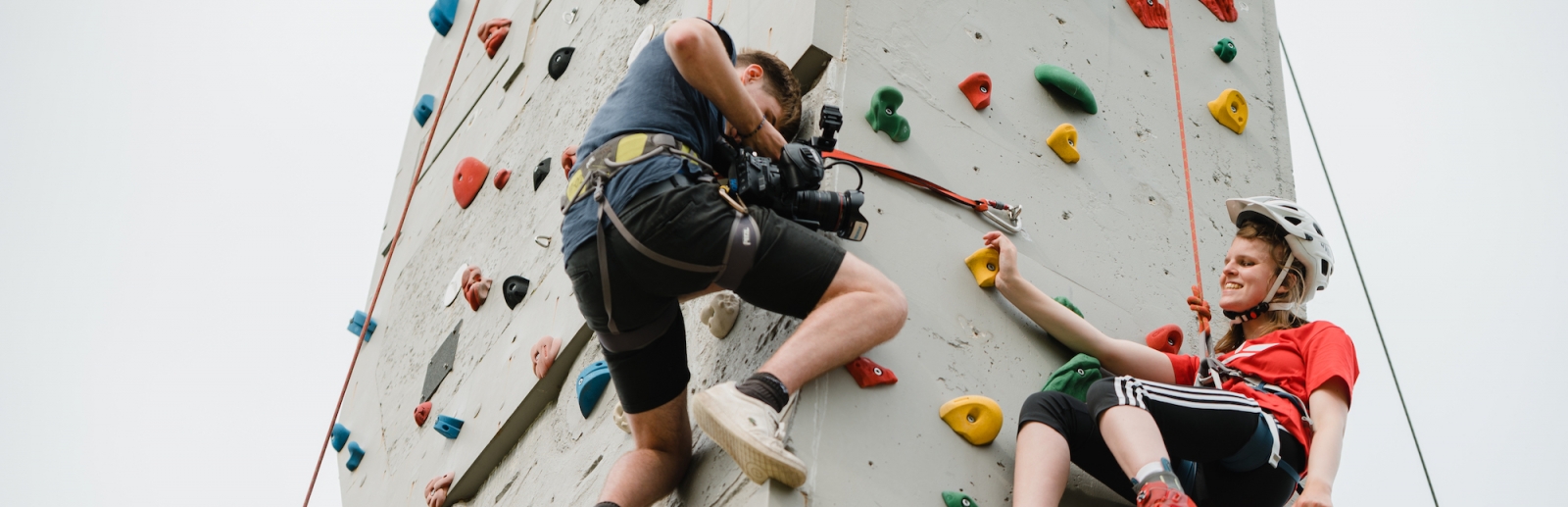 Vier Kletterer an einer Boulderwand