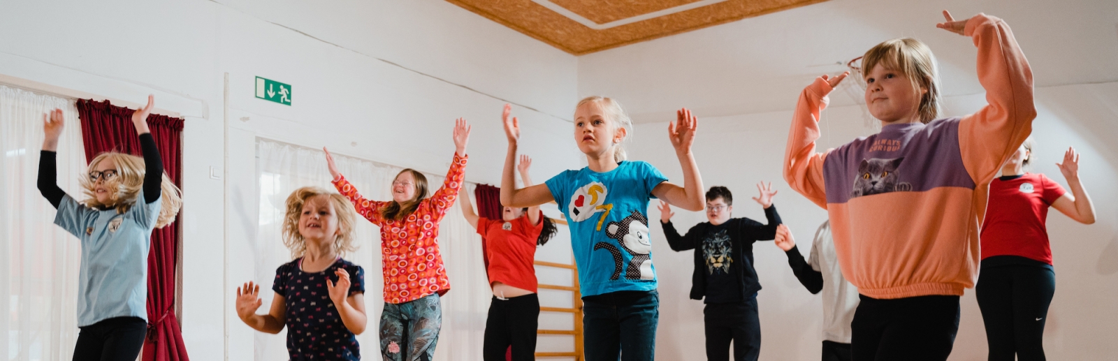 Gruppe von Kindern beim Sprung in der Turnhalle