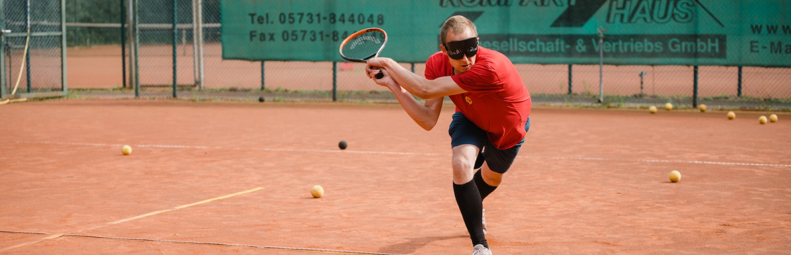 Blinder Tennisspieler beim Schlag