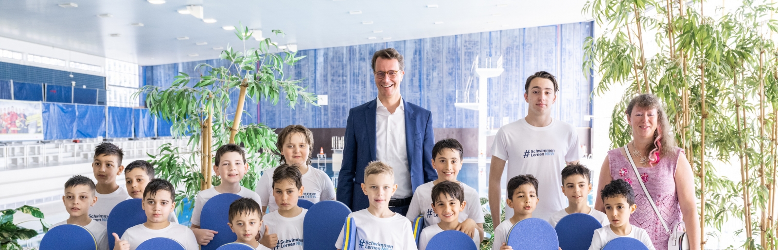 Hendrik Wüst und Andrea Milz mit Kindern im Schwimmbad