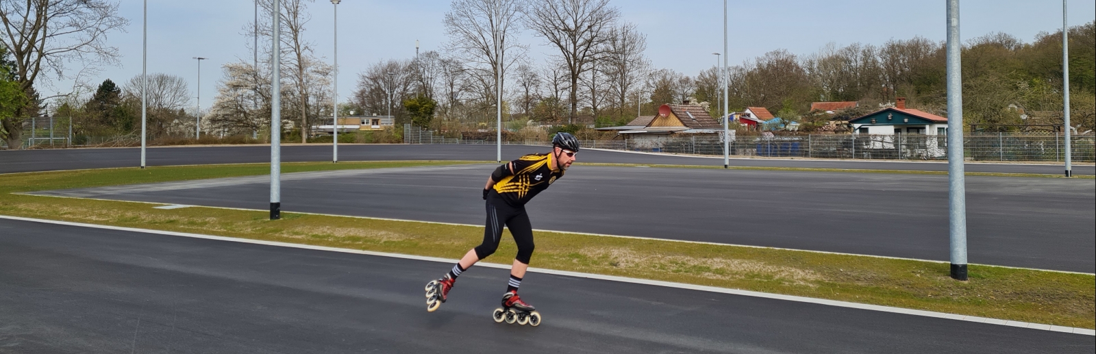 Inline-Skater auf einer asphaltiereten Sportplatzbahn