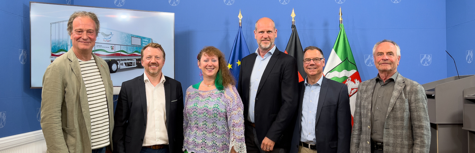 Andrea Milz mit Personen auf einer Bühne bei Vorstellung des Schwimmcontainers "narwali"