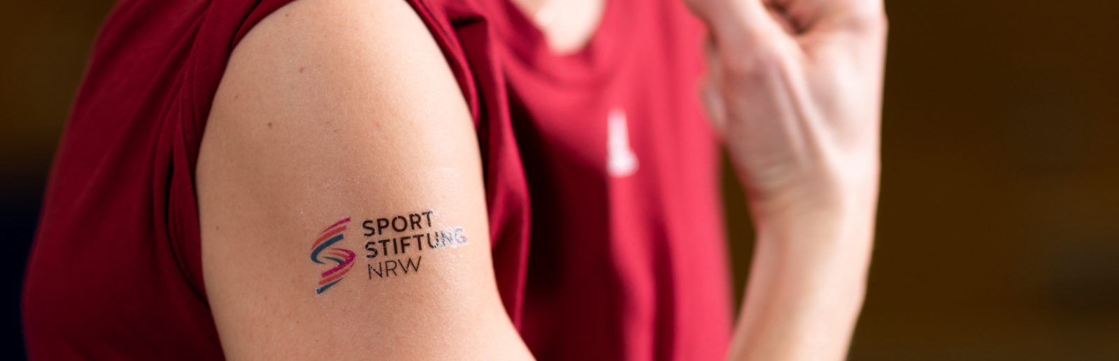 Das Logo der Sportstiftung NRW abgebildet auf dem Arm eines Athletens