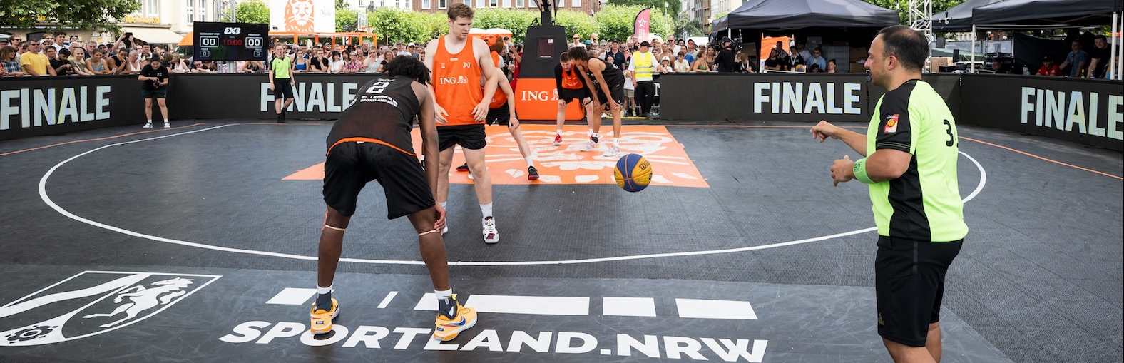 Basketballspieler mit Sportland.NRW-Schriftzug auf dem Boden
