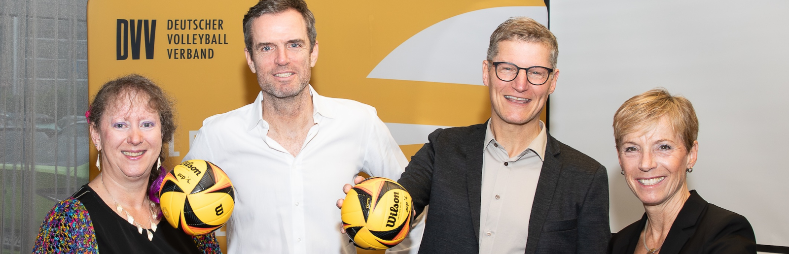 Andrea Milz sowie weitere drei Personen mit Volleybällen in der Hand