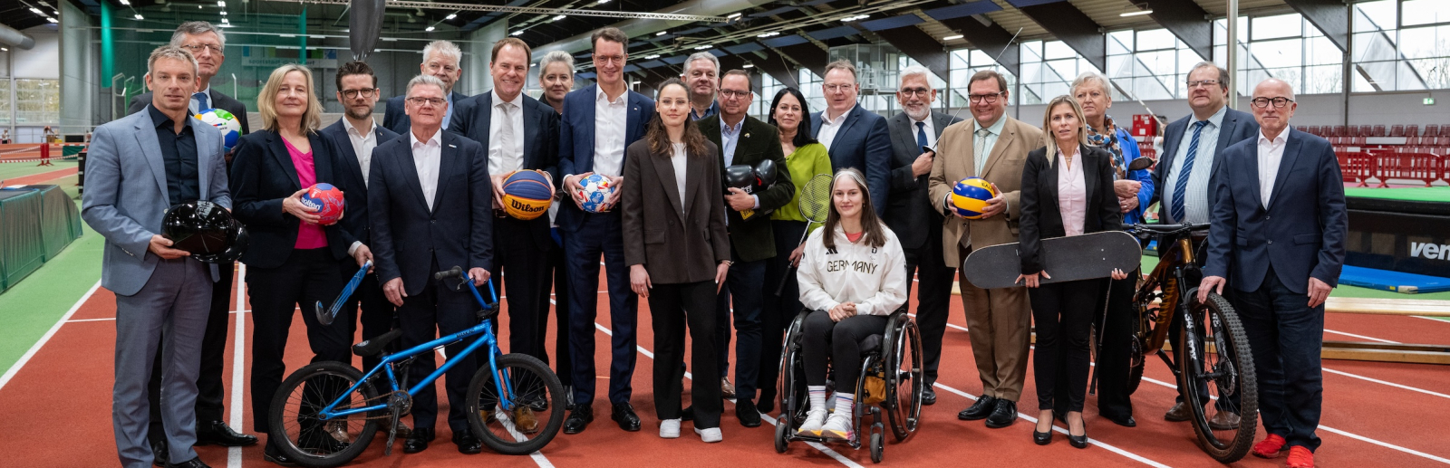 Gruppenbild in der Leichtathletik-Halle in Düsseldorf mit Teilnehmenden der Pressekonferenz