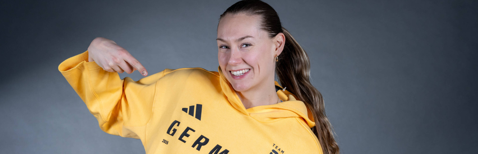 Laura Nolte im Team D-Hoodie vor dunklem Hintergrund