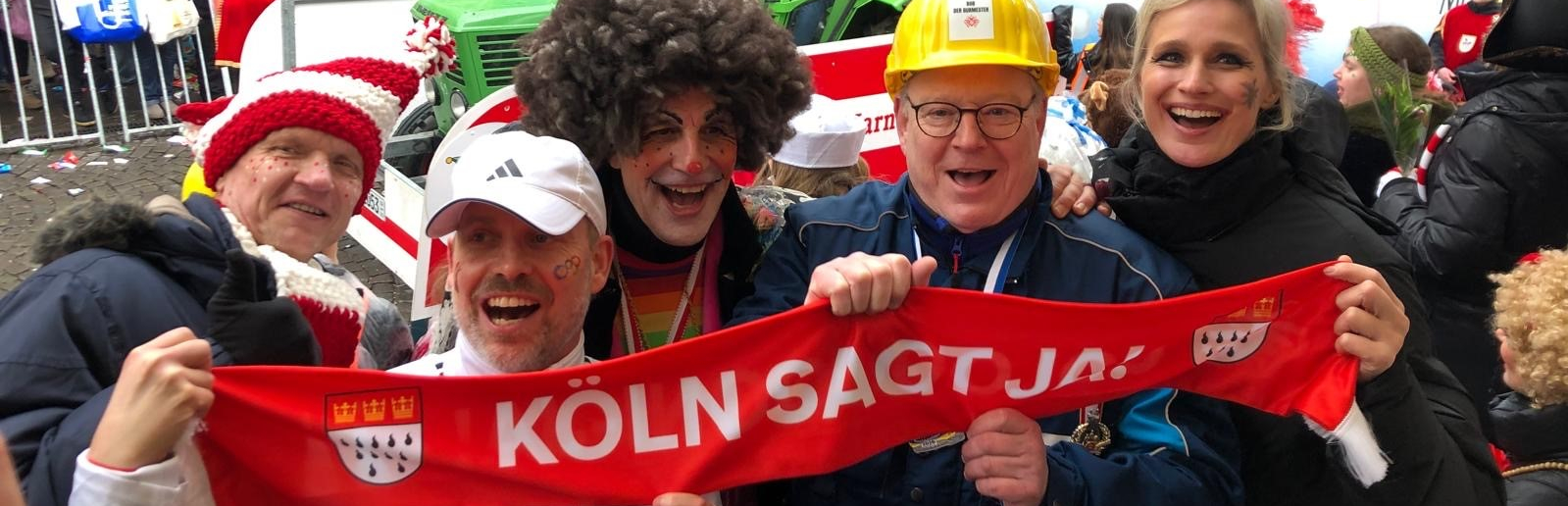 Personen mit rotem Spruchband "Köln sagt ja"