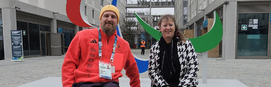 Andrea Milz und ein Para Athlet im Rollstuhl vor einer Agitos Skulptur in Mailand