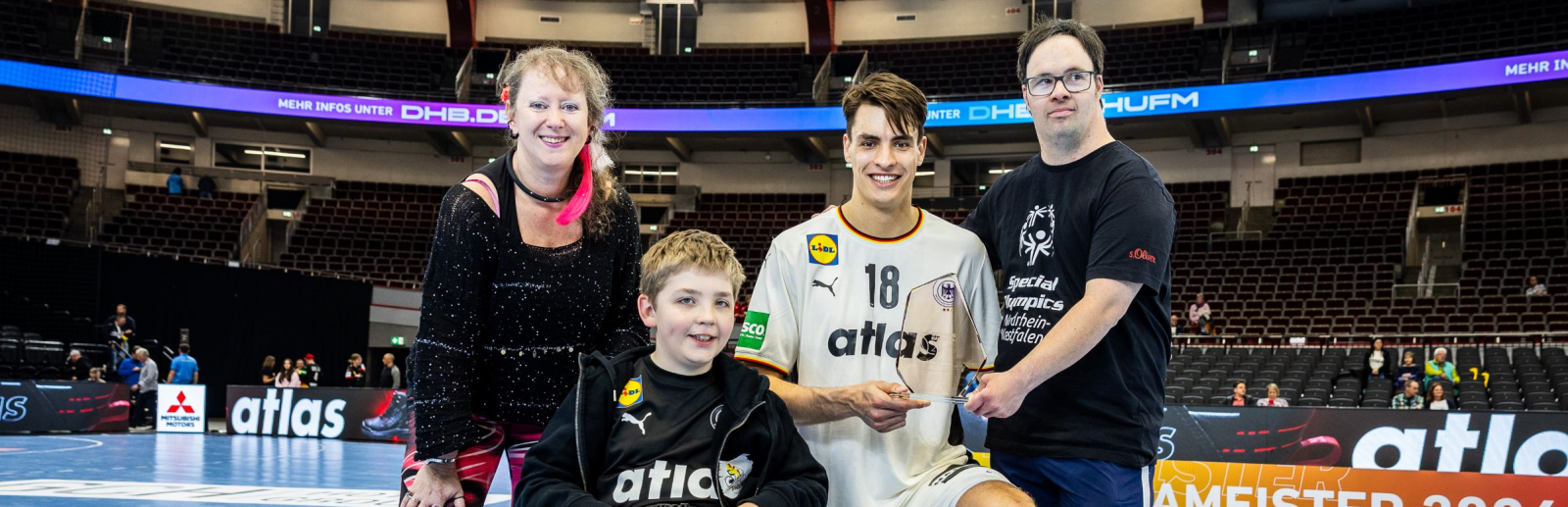 Andrea Milz und Julian Köster mit zwei weiteren Jugendlichen, einer davon im Rollstuhl, auf einem Handballfeld