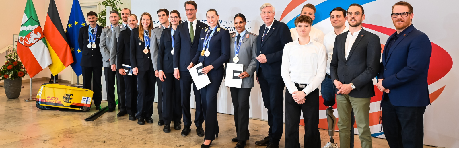 Gruppe mit olympischen und paralympischen Sportlerinnen und Sportlern, in der Mitte Ministerpräsident Wüst