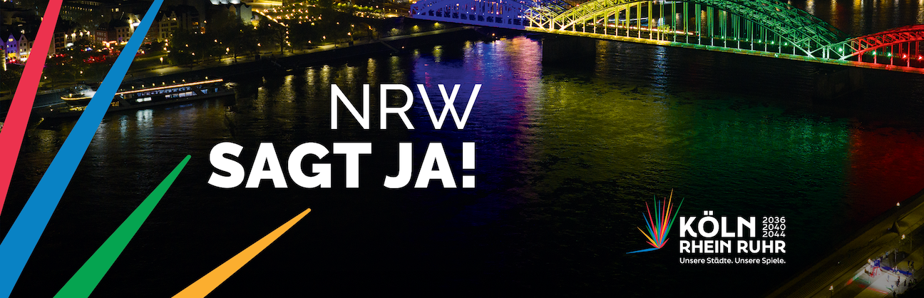Schriftzug "NRW sagt JA! und "66% Zustimmung" vor der Skyline von Köln bei Nacht