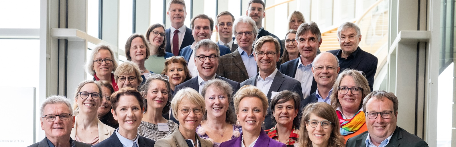 Gruppe von mehreren Personen vor einer Fensterfront