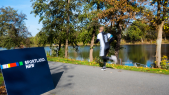 Sportland.NRW-Banner an einer Joggingstrecke