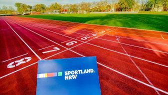 Laufbahn mit blauem Sportland.NRW-Schild