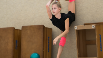 Amelia Kuznetsowa macht einen Spagath an der Wand