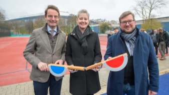 Drei Personen vor einer Tartanbahn