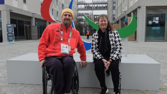 Andrea Milz und ein Para Athlet im Rollstuhl vor einer Agitos Skulptur in Mailand