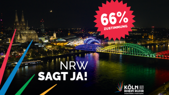 Schriftzug "NRW sagt JA! und "66% Zustimmung" vor der Skyline von Köln bei Nacht