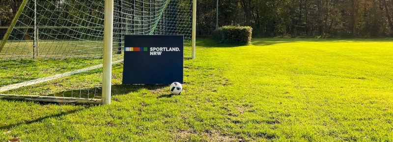 Sportland.NRW Logo auf Fußballfeld mit Ball